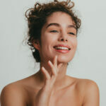 Portrait of a beautiful young woman with curly hair without make-up, studio shot in front of white background